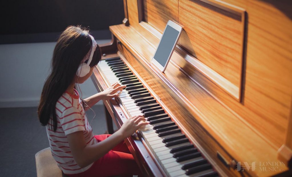 child taking online piano lesson