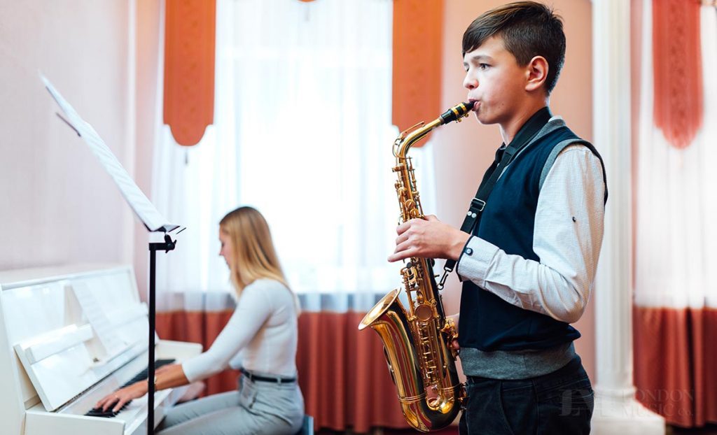 Student playing saxophone with piano accompanist