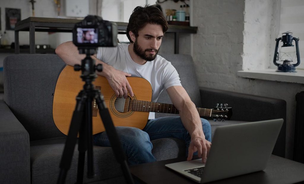 man teaching guitar online